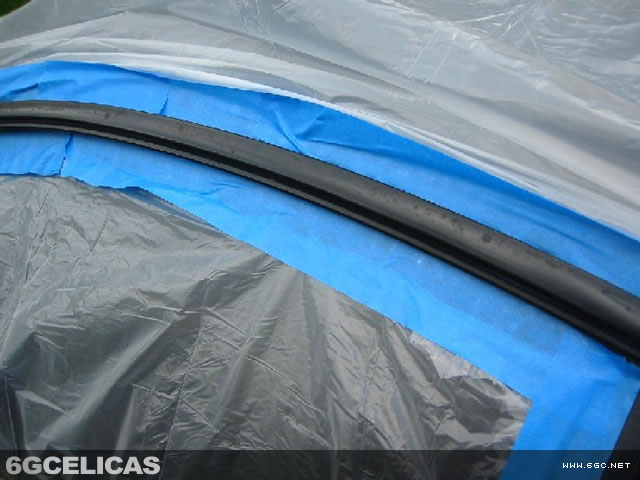 Close-up of masked window trim showing precise tape placement